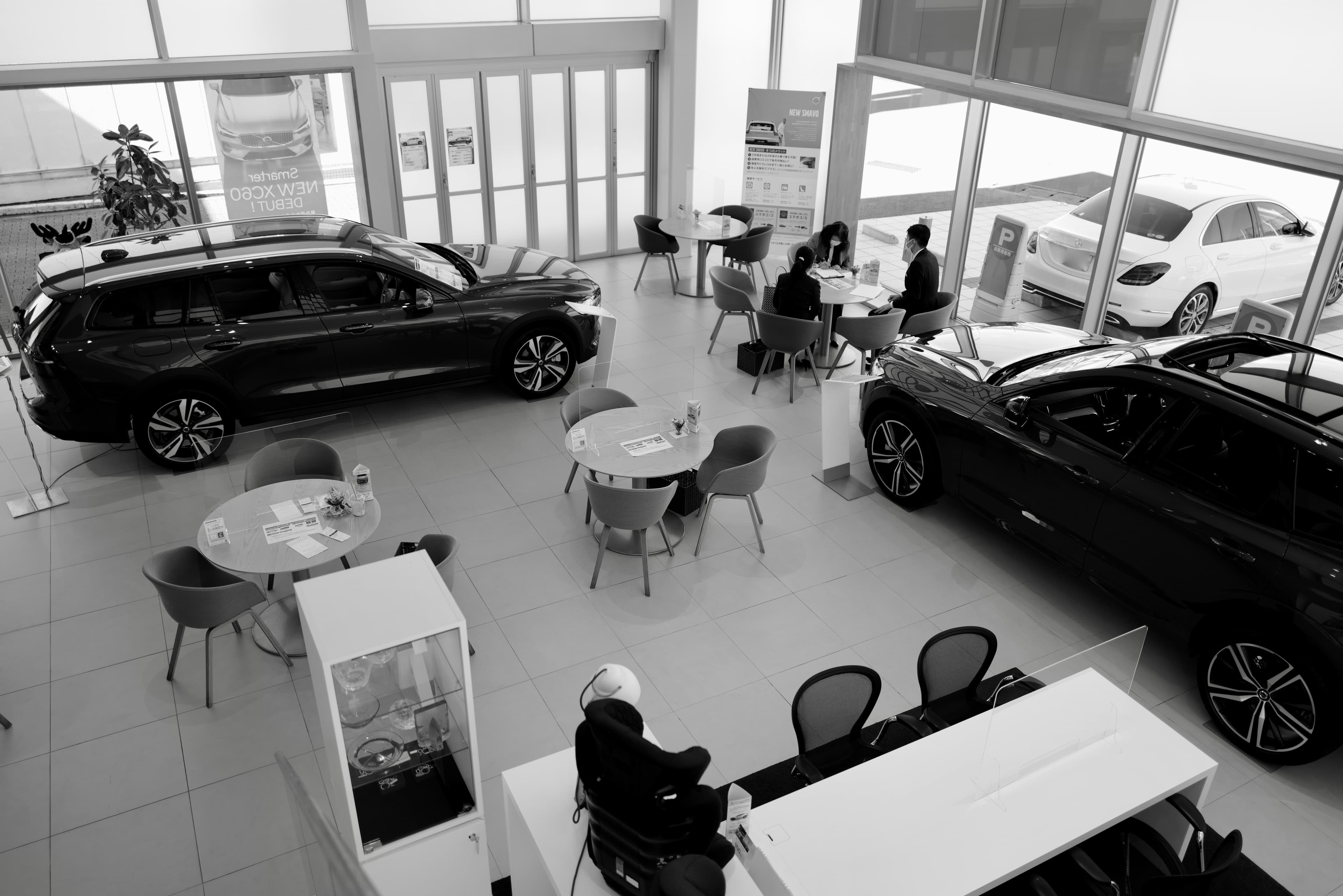 Modern dealership customer lounge with espresso bar and waiting customers.
